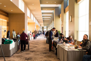 Picture of the hallway outside of dealers with people talking and walking